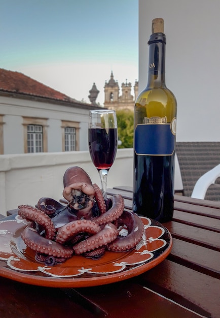 Rotweinflasche mit Glas und Oktopus vom Hotelbalkon