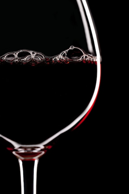 Rotweinglas-Silhouette auf schwarzem Hintergrund mit Blasen
