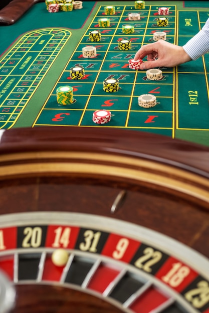 Roulette und Stapel von Spielmarken auf einem grünen Tisch