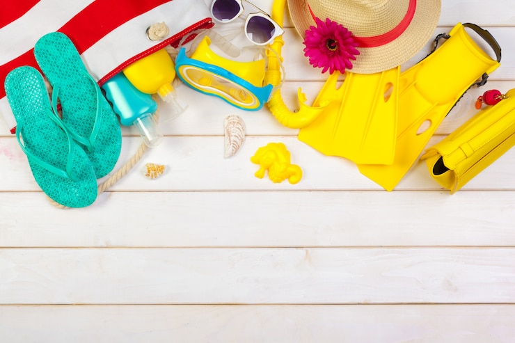 Foto roupa de praia e acessórios em um branco de madeira