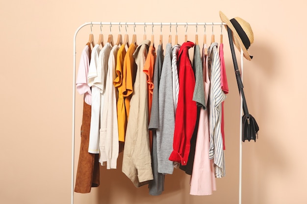 Roupas da moda em cabides em um guarda-roupa em um fundo colorido