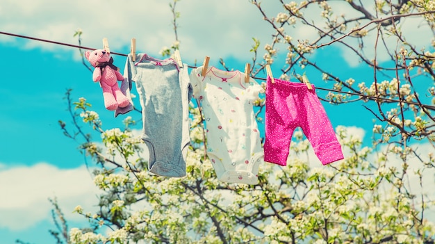 Roupas de bebê estão secando na rua. Foco seletivo.