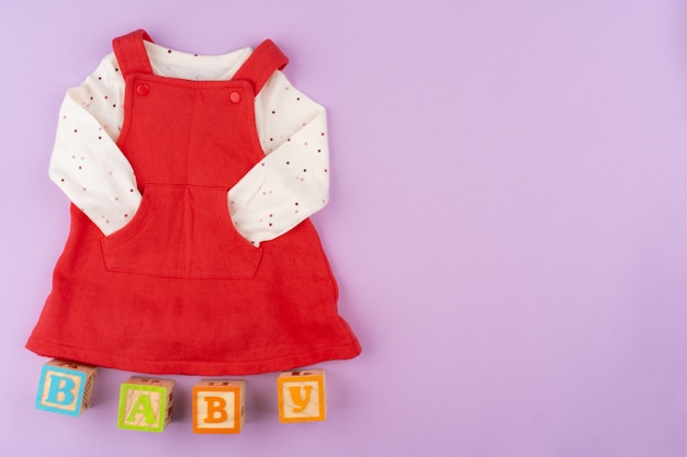 Roupas de bebê menina na superfície pastel lilás