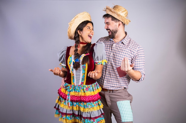 Foto roupas de casal brasileiro da festa junina arraial festa de são joão namorado e namorada convidando as mãos