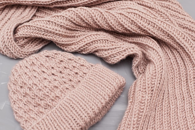Roupas de inverno tricotadas ordenadamente empilhadas em um fundo branco A superfície dos têxteis de lã das mulheres Textura de malha closeup O fundo é cinza Roupas casuais