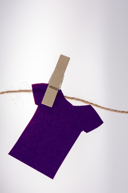 Roupas de papel penduradas em uma corda com a ajuda de pinças de roupa
