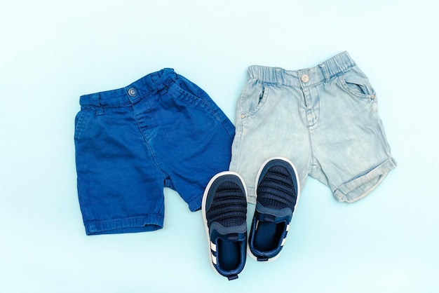 Roupas e acessórios azuis para bebês de verão com shorts jeans sapatilhas roupa infantil de moda modernaconjunto de roupas infantis para a primavera ou verão vista superior plana layoverheadmockup