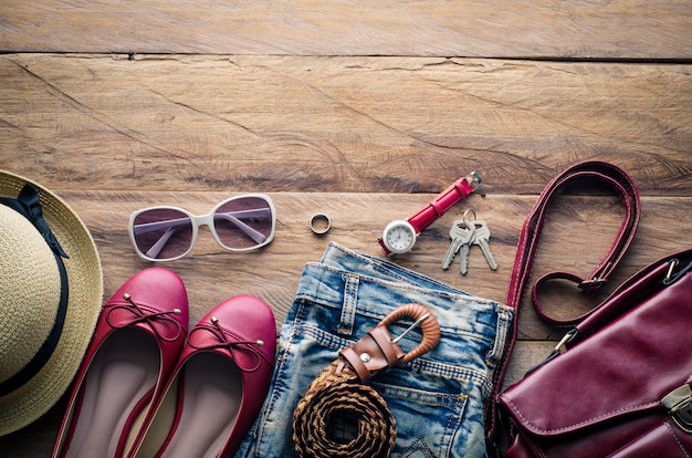 Foto roupas e acessórios para as mulheres, colocados em um piso de madeira.