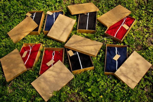 Roupas esportivas coloridas com etiquetas dobradas em caixas de papelão estão no chão com roupas embaladas em grama vista superior desembalando compras