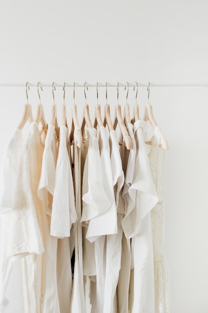 Roupas femininas em cabide. Composição de moda mínima em branco.