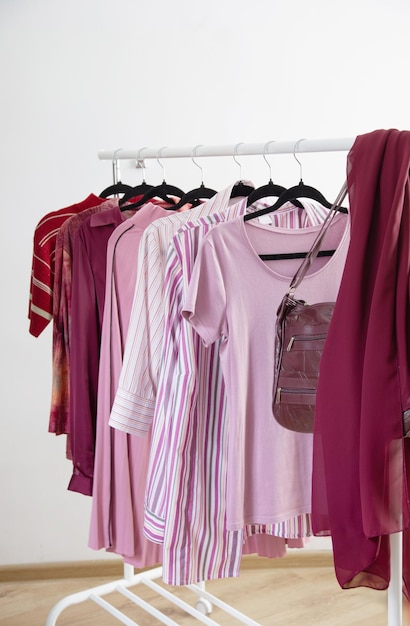 roupas femininas em cor-de-rosa e burgundy cores da moda em um gancho