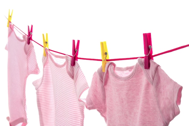 Roupas infantis na linha de roupa contra o fundo branco