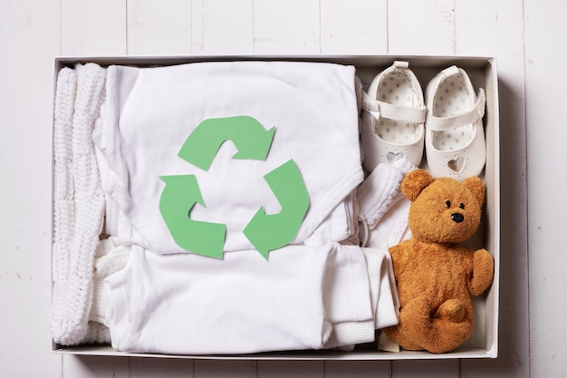 Roupas infantis, sapatos e brinquedos em caixa de doação Conceito de reutilização de reciclagem de roupas de segunda mão