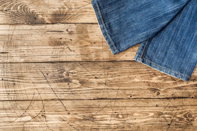 Roupas jeans e acessórios na superfície de madeira marrom