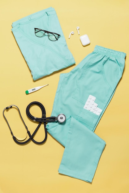 Roupas médicas modernas para médicos e enfermeiras dispostas em uma foto superior de fundo de papel