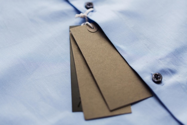 roupas, moda, roupa formal, conceito de compras e objetos - close-up da camisa com etiqueta de preço