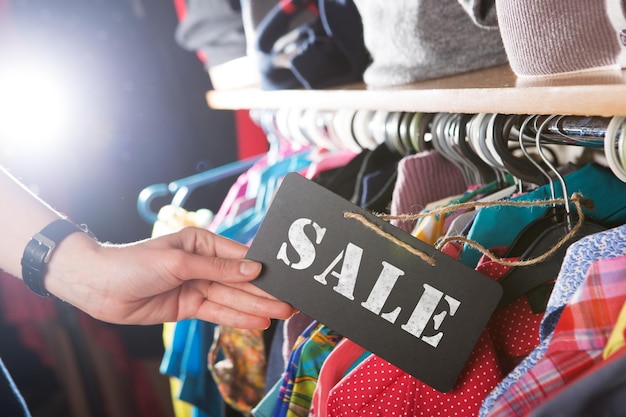 Roupas penduradas na prateleira na loja de moda