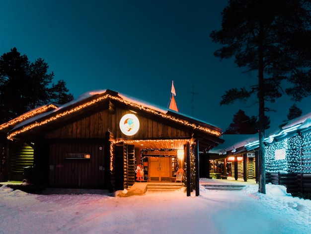 Rovaniemi, Finlandia - 6 de marzo de 2017: Oficina de Santa Claus en Santa Village con árboles de Navidad en la Laponia finlandesa. Escandinavia, en el Círculo Polar Ártico en invierno. Por la noche. Exterior