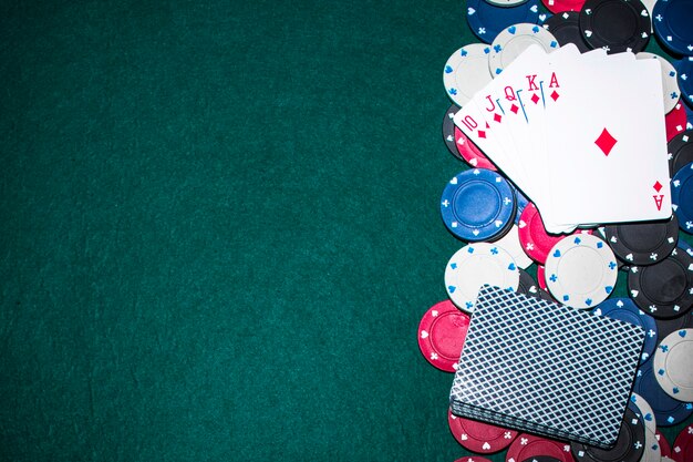 Royal flush baralho e fichas de casino em fundo verde poker