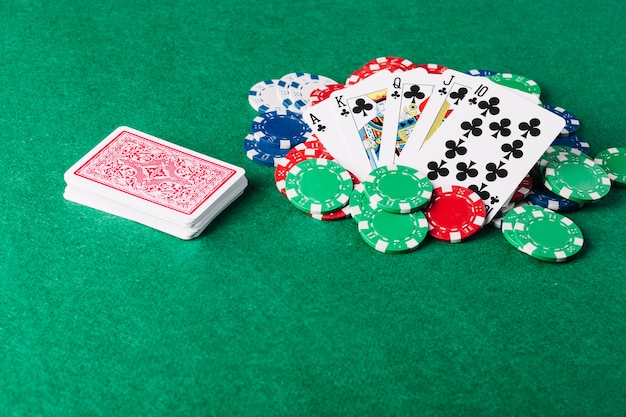 Foto royal flush spielkarte und casino chips auf grünem pokertisch