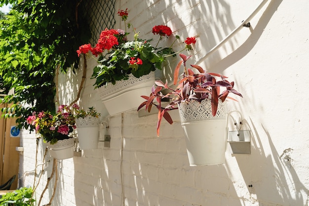 Rua colorida floral com parede de tijolos brancos em cidade mediterrânea