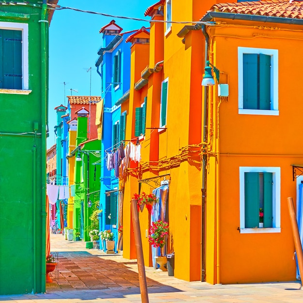 Rua com casas de cores vivas na Ilha de Burano, Veneza, Itália