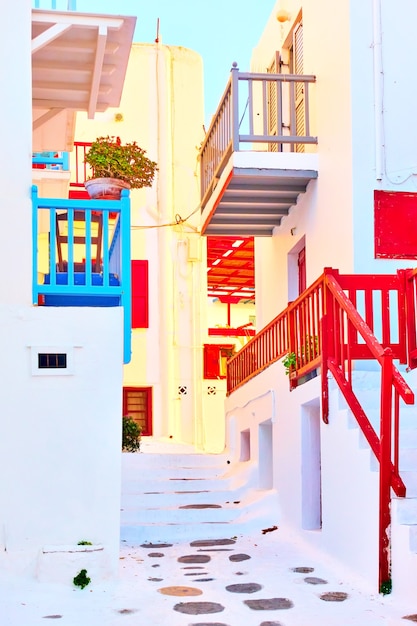 Rua com casas tradicionais caiadas de branco com varandas na cidade de mykonos, grécia