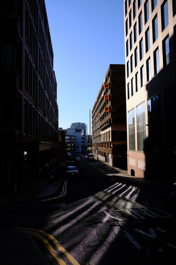 Foto rua da cidade em meio a edifícios contra o céu claro