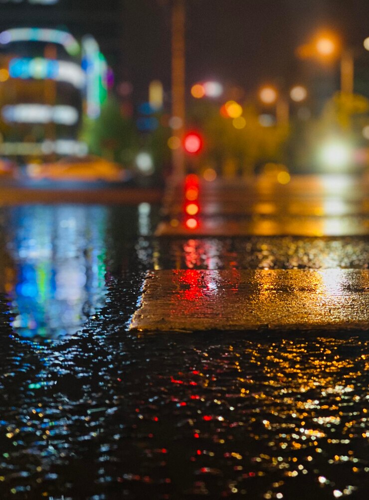 Foto rua da cidade iluminada durante a estação chuvosa à noite
