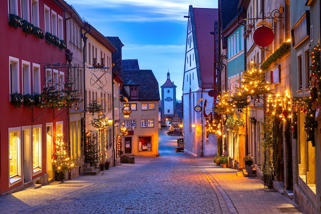 Rua de natal decorada e iluminada com portão e torre plonlein na cidade velha medieval de rothenburg ob der tauber, baviera, sul da alemanha