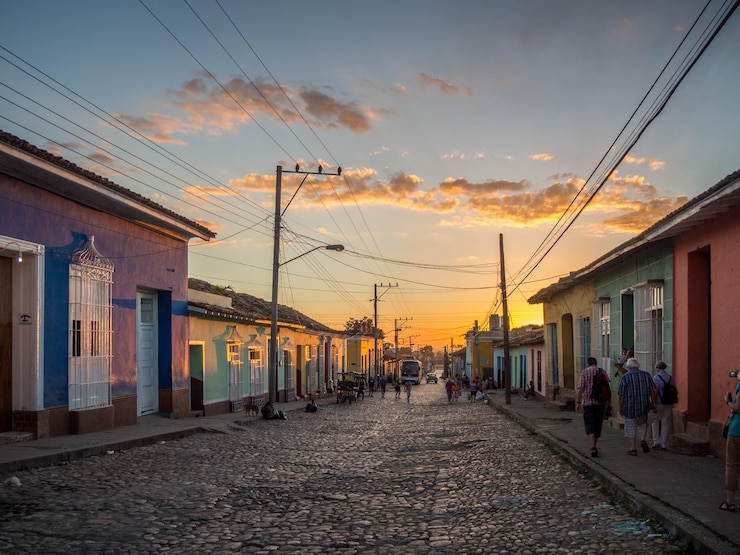 Foto rua de paralelepípedos em meio a casas contra o céu durante o pôr do sol