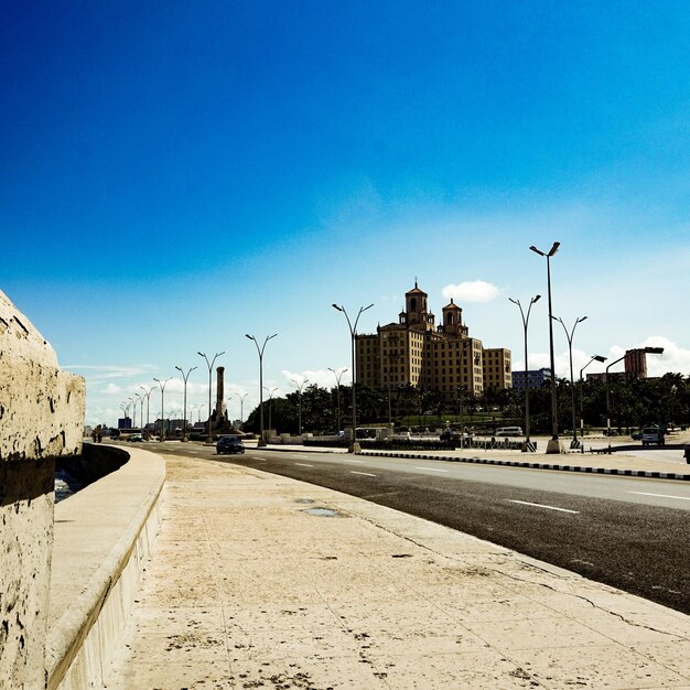 Foto rua em meio a edifícios contra o céu azul claro