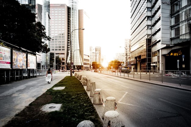 Foto rua em meio a edifícios na cidade durante o pôr do sol