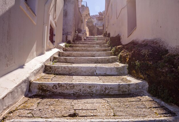 Foto rua estreita da cidade de grécia kea island ioulis com escadas e edifícios tradicionais