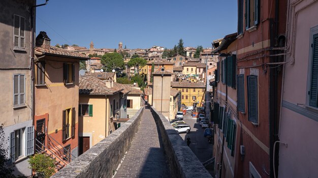 Rua estreita para pedestres entre antigas casas de tijolos na antiga cidade italiana em um dia ensolarado Perugia Itália