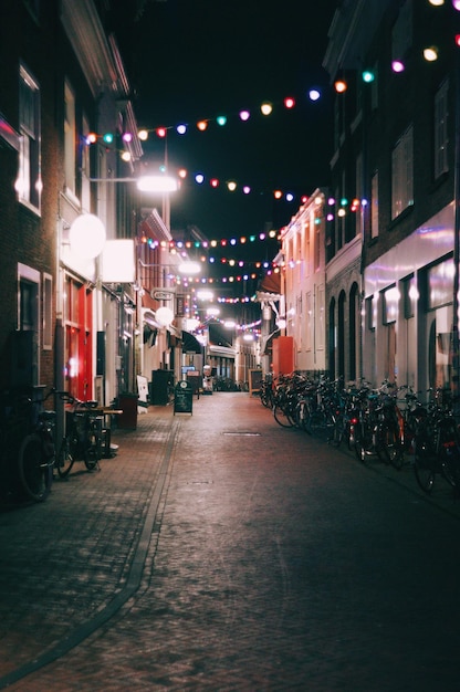 Foto rua iluminada em meio a edifícios à noite