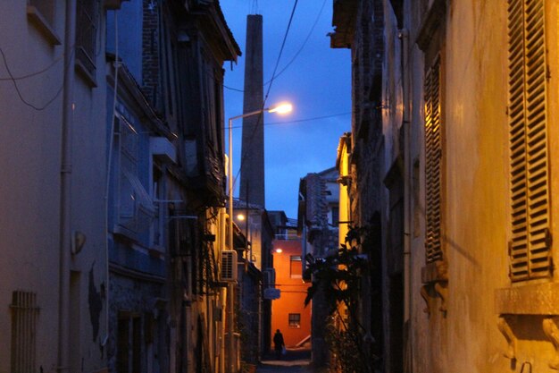 Foto rua iluminada em meio a edifícios contra o céu ao anoitecer