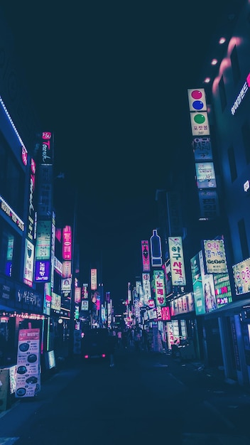 Rua iluminada em meio a edifícios na cidade à noite