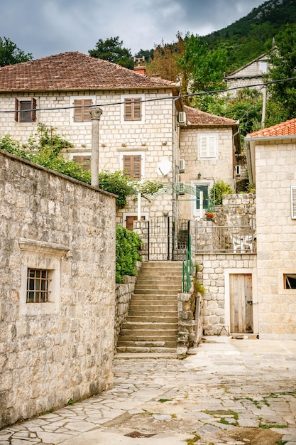 Rua pequena com casas de pedra residenciais antigas em Perast