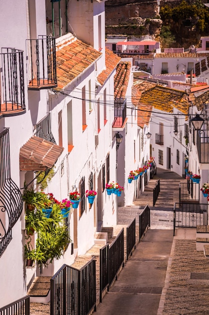 Rua pitoresca de Mijas com vasos de flores nas fachadas aldeia branca andaluza Costa del Sol Sul da Espanha