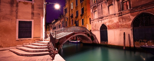 Foto rua veneziana à noite ponte sobre o canal veneza itália