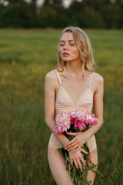 Rubia en el campo al atardecer en lencería