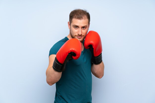 Rubia deporte hombre azul pared con guantes de boxeo