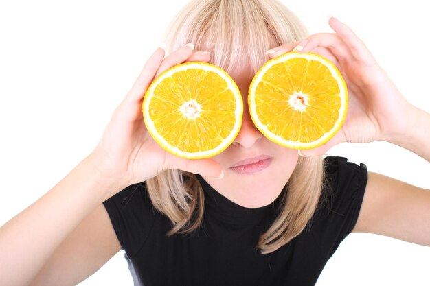 Rubia divertida con dos rodajas de naranja en lugar de ojos sobre blanco