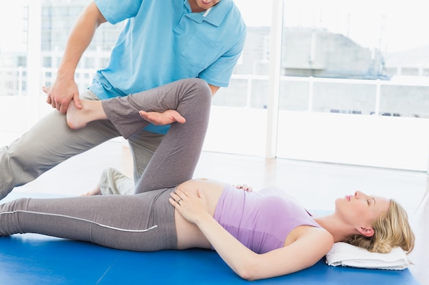 Foto rubia embarazada recibiendo un masaje relajante