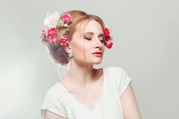 Rubia con flores en su cabello hermosa delicada.