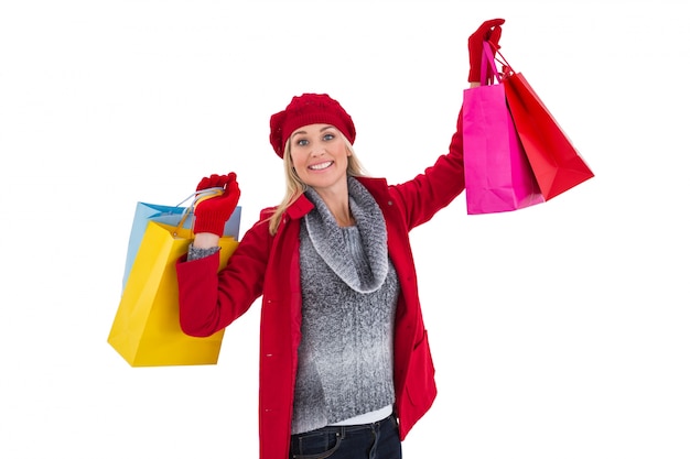 Rubia en ropa de invierno con bolsas de compras