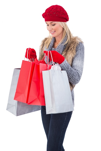 Rubia en ropa de invierno con bolsas de compras