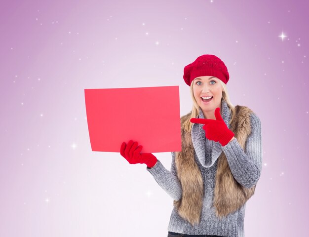 Rubia en ropa de invierno con cartel rojo