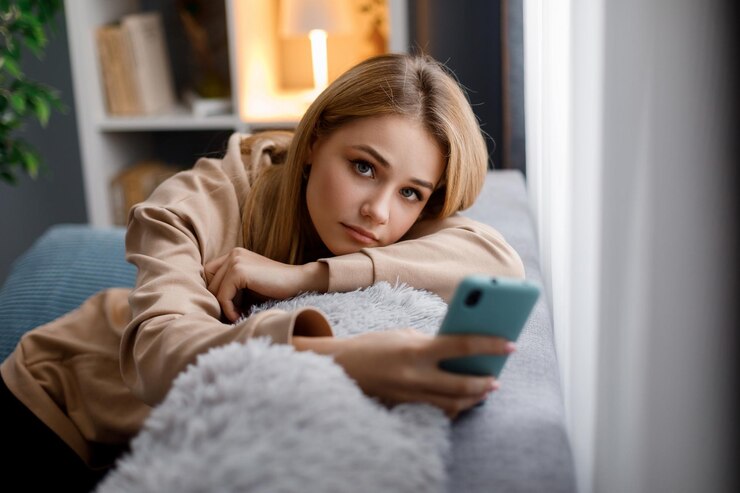 Rubia con smartphone en el sofá